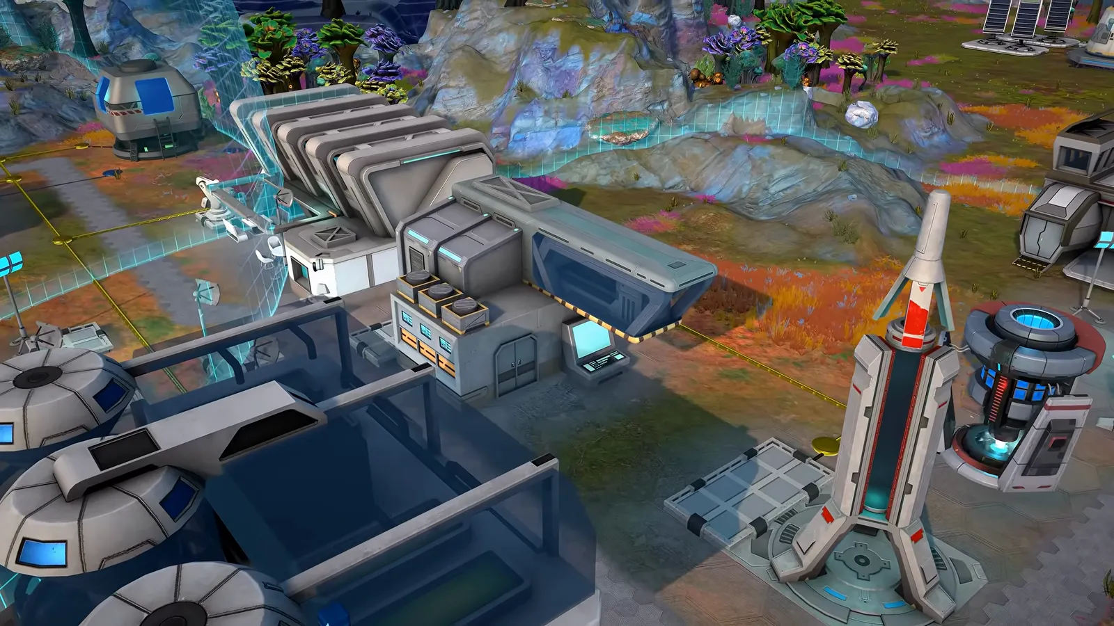 Official gameplay footage of grey industrial machinery blocks with a cyan pipe beside a tall white tower with red markings